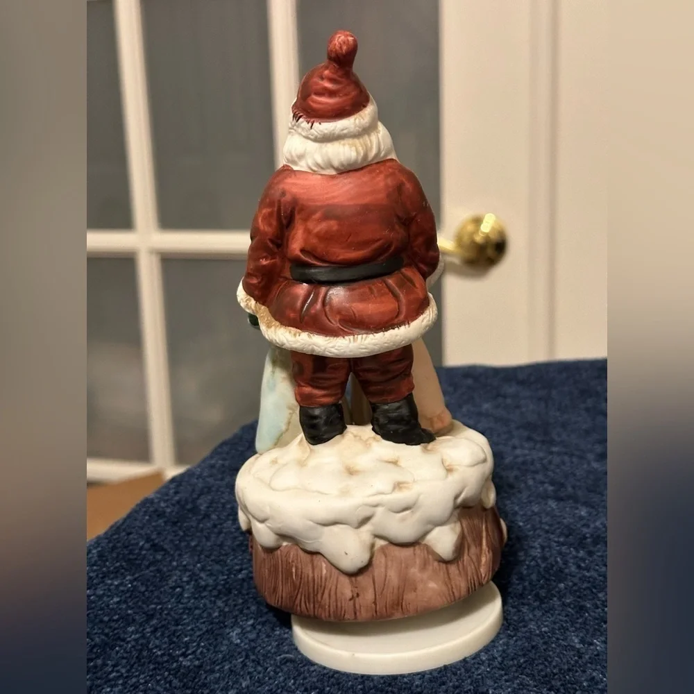 Beautiful Santa hugs 2 small children and plays Santa Claus is Coming to Town.